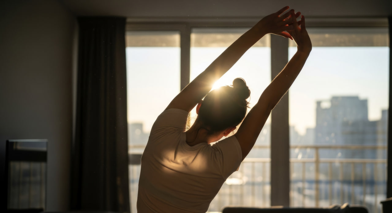 Femme effectuant un mouvement d’échauffement au lever du soleil
